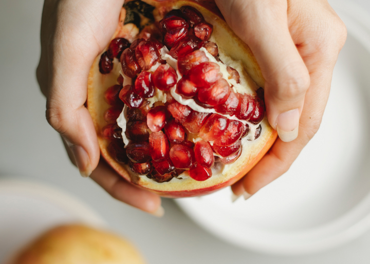 A person holds an open pomegranate in both hands