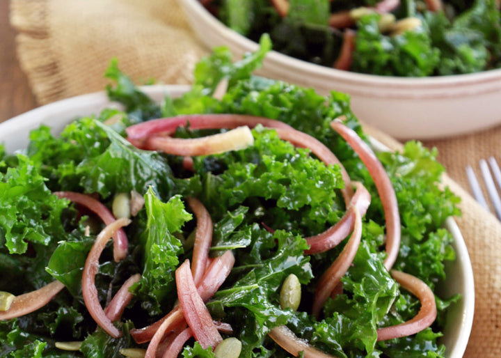 A kale salad topped with red onion