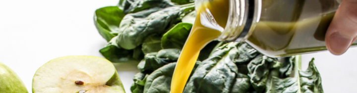A person pours green juice into a cup