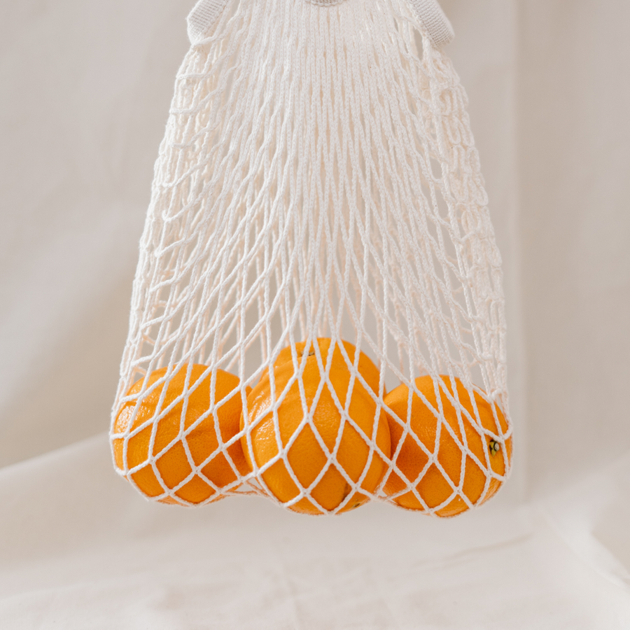 Oranges inside of a net grocery bag